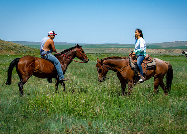Two people riding horses